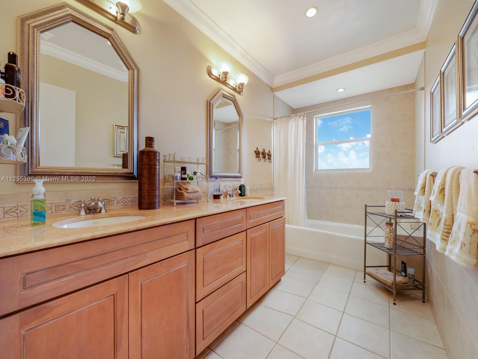7001 Southwest 126th Street Pinecrest, FL 33156 - Photo 12 of 19 a spacious bathroom with a double vanity sink a mirror and a bathtub