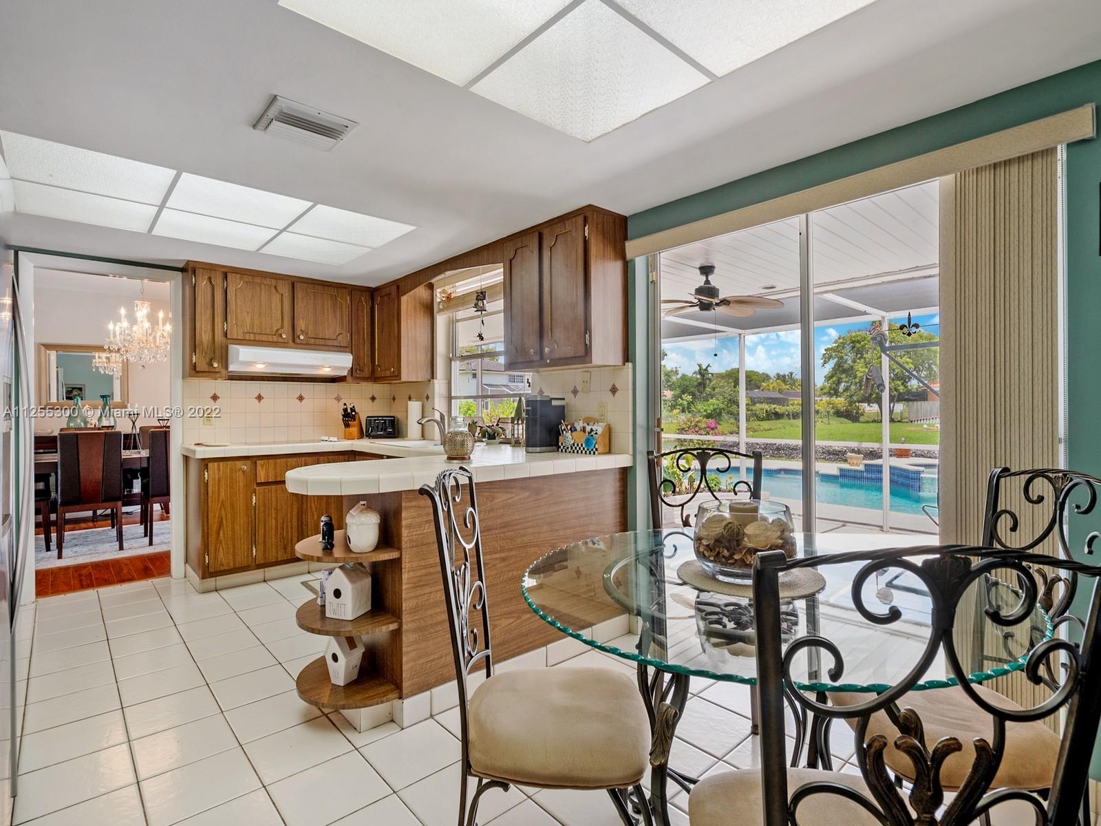 7001 Southwest 126th Street Pinecrest, FL 33156 - Photo 7 of 19 a kitchen with a table chairs and a refrigerator