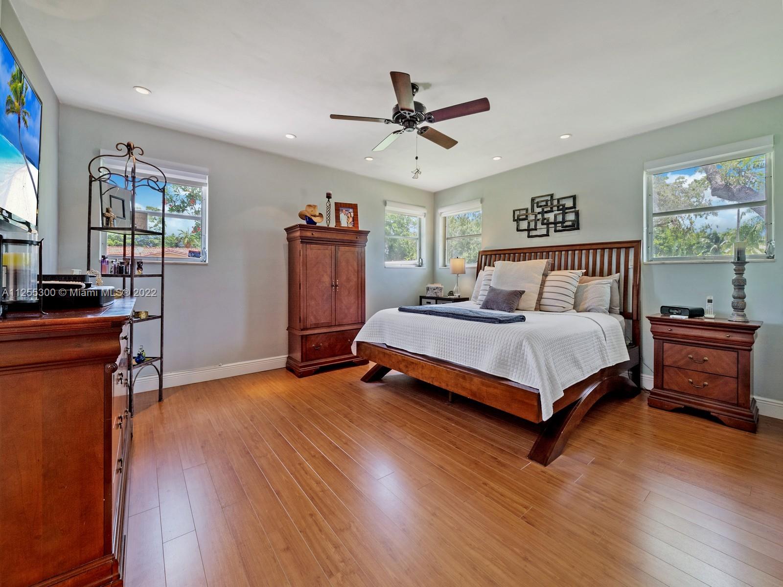 7001 Southwest 126th Street Pinecrest, FL 33156 - Photo 8 of 19 a bedroom with a bed and wooden floor