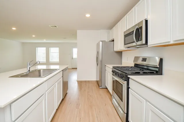 a kitchen with stainless steel appliances granite countertop a sink stove and refrigerator