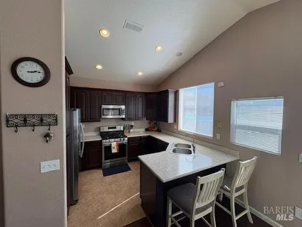 a kitchen with stainless steel appliances granite countertop a stove refrigerator sink and cabinets