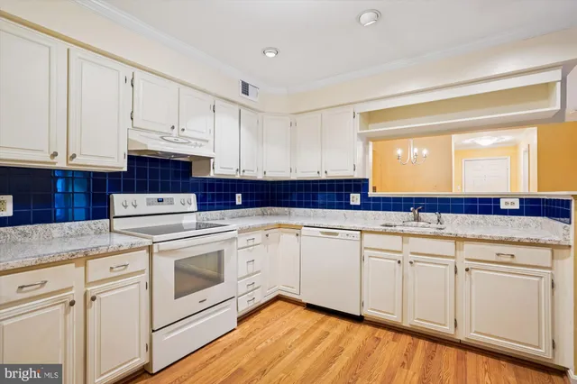a kitchen with white cabinets sink and white appliances