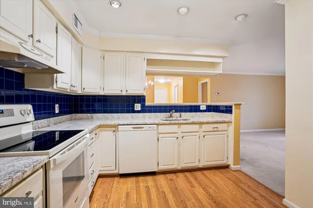 a kitchen with granite countertop a sink and cabinets with wooden floor