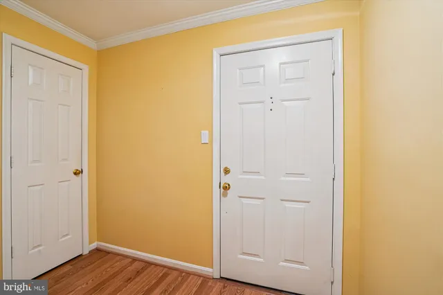 an empty room with wooden floor and closet area