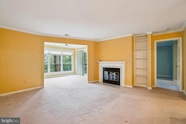 a view of an empty room with a fireplace and a window