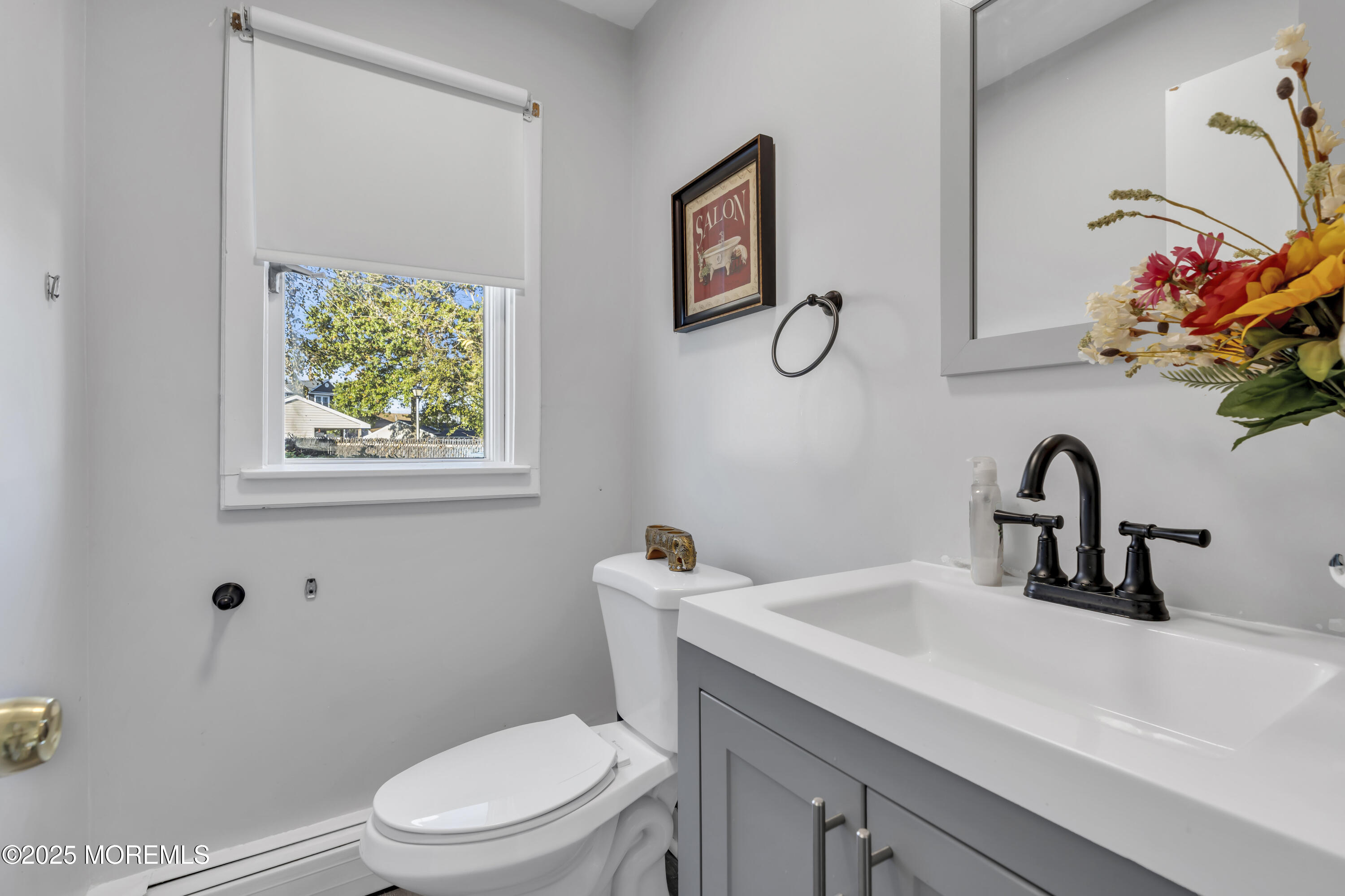 934 7th Street Union Beach, NJ 07735 - Photo 29 of 50 a bathroom with a granite countertop sink a toilet and a mirror