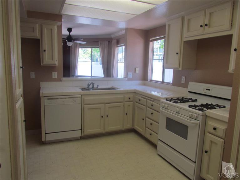 1818 Rory Lane, Unit 2 Simi Valley, CA 93063 - Photo 3 of 13 a kitchen with white cabinets and white appliances