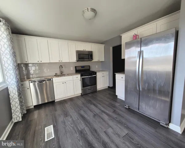 a kitchen with a refrigerator a sink and a stove top oven