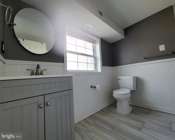 a bathroom with a toilet sink and mirror