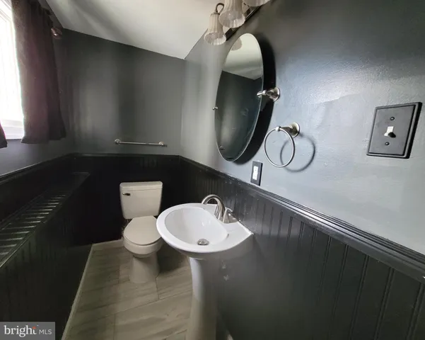 a bathroom with a sink a toilet and mirror