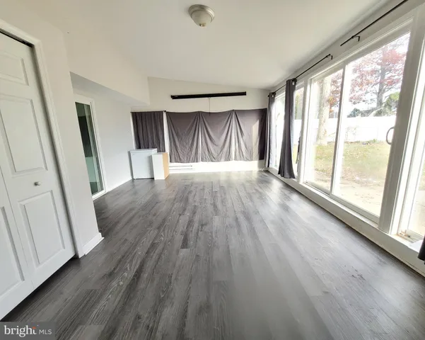 a view of a livingroom with wooden floor and a sink
