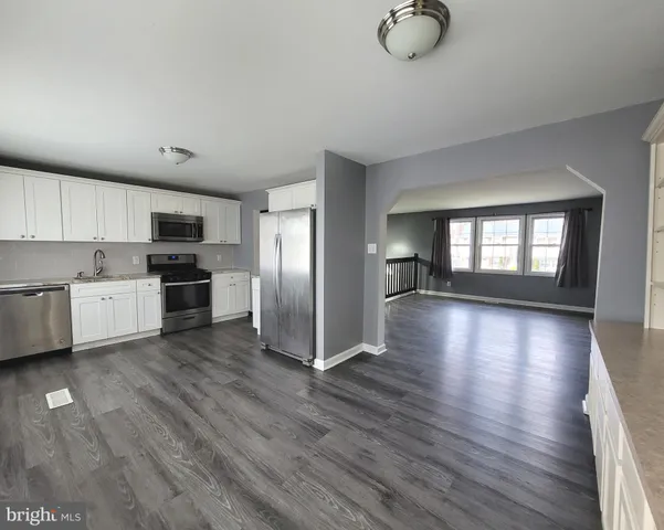 a view of kitchen with sink microwave refrigerator and cabinets