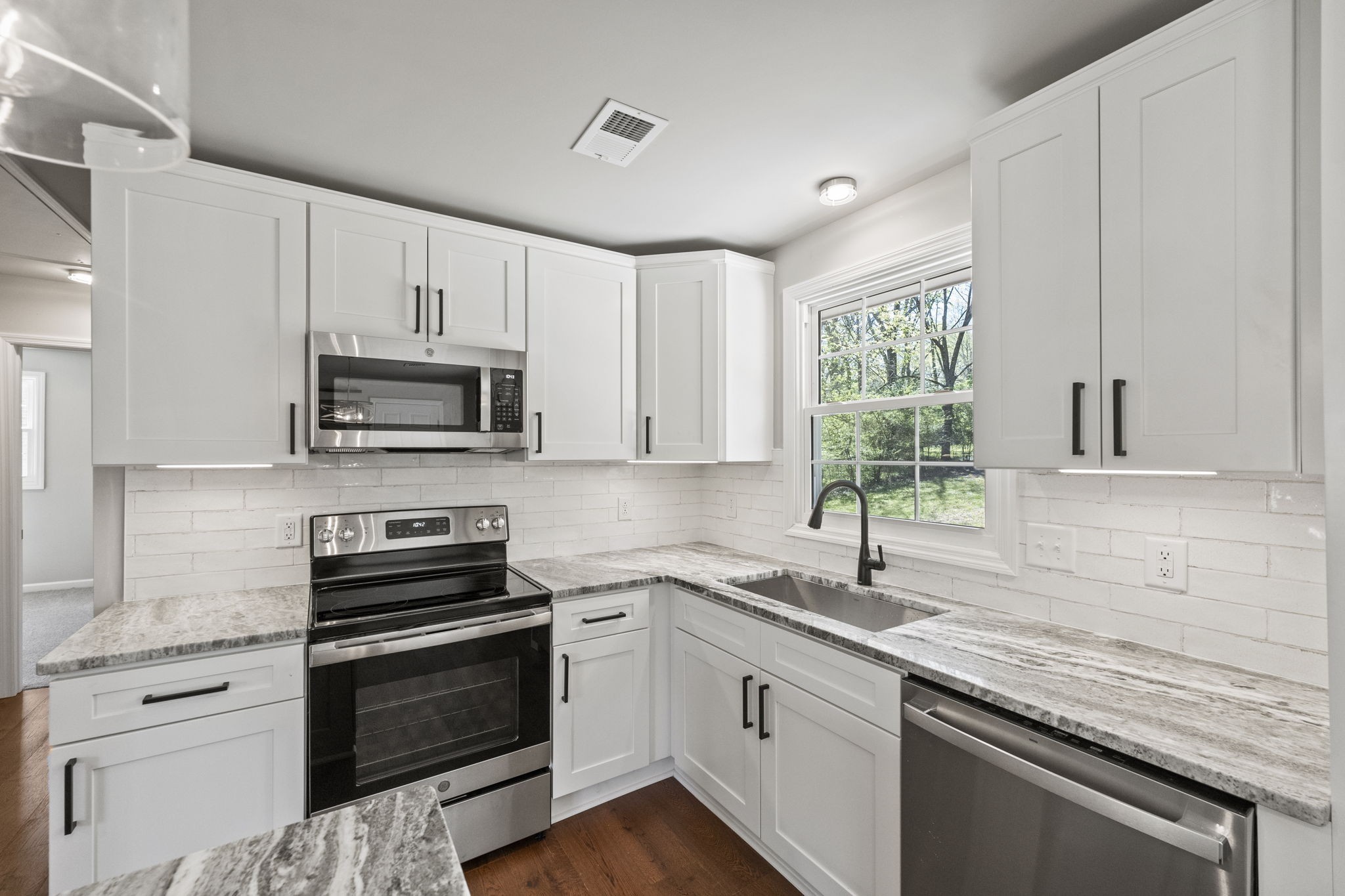 128 South Valley Road Hendersonville, TN 37075 - Photo 15 of 30 a kitchen with white cabinets appliances a sink and a window