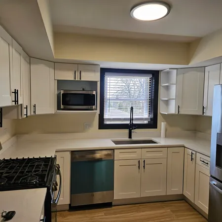 a kitchen with stainless steel appliances granite countertop a sink and a stove