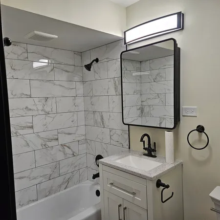 a bathroom with a tub sink toilet and mirror