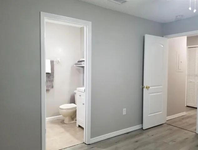 an empty room with wooden floor and closet area