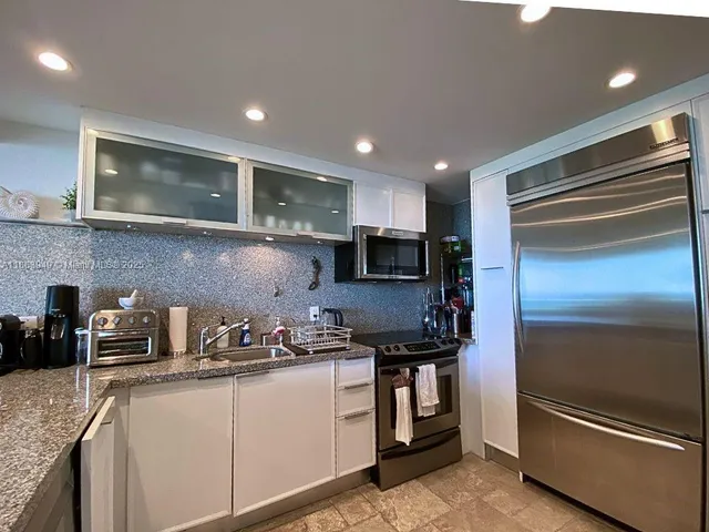 a kitchen with kitchen island granite countertop stainless steel appliances and sink