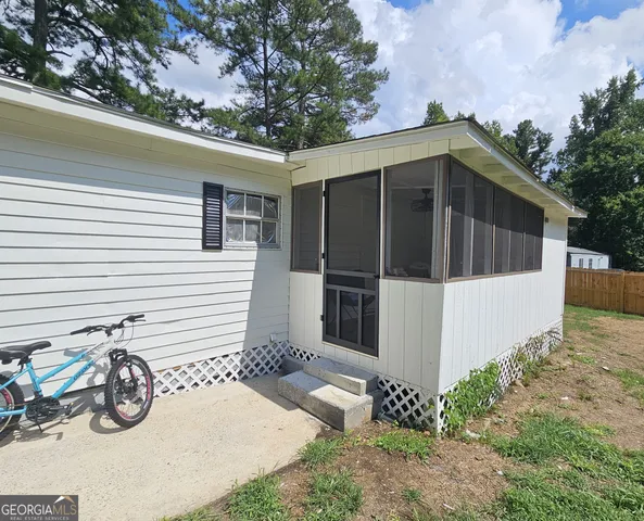 a view of a wooden house with a small yard