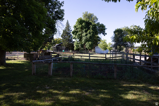 827 South 600 East Logan, UT 84321 - Photo 29 of 30 Expansive outdoor space featuring a fenced area, mature trees, and a distant outbuilding