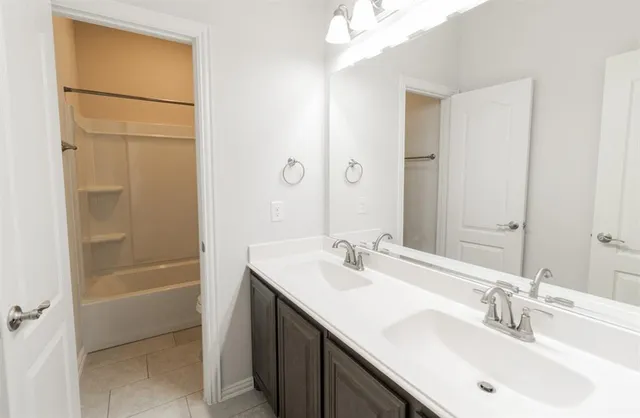 a bathroom with a sink a shower a mirror and a bathtub