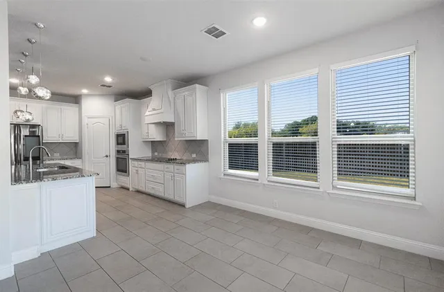 a kitchen with stainless steel appliances granite countertop a stove a sink and a refrigerator