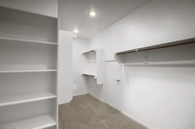 a view of walk in closet with empty racks