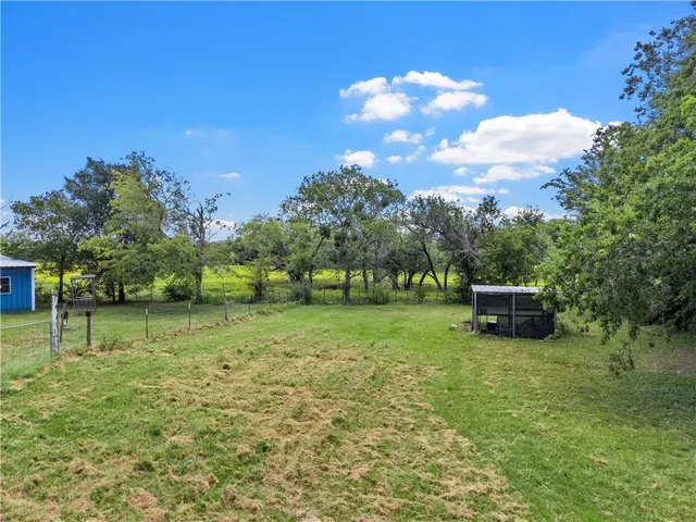 a view of backyard with huge green area and covered with tall trees