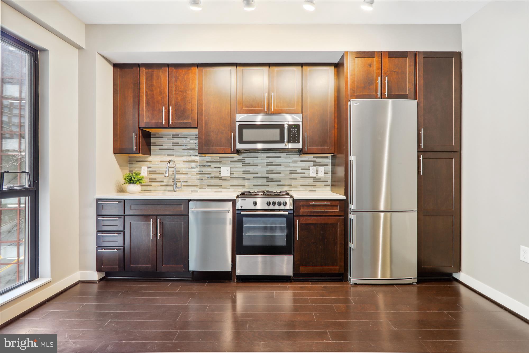 1320 Fenwick Lane, Unit 312 Silver Spring, MD 20910 - Photo 13 of 44 a kitchen with stainless steel appliances granite countertop a refrigerator and a stove top oven