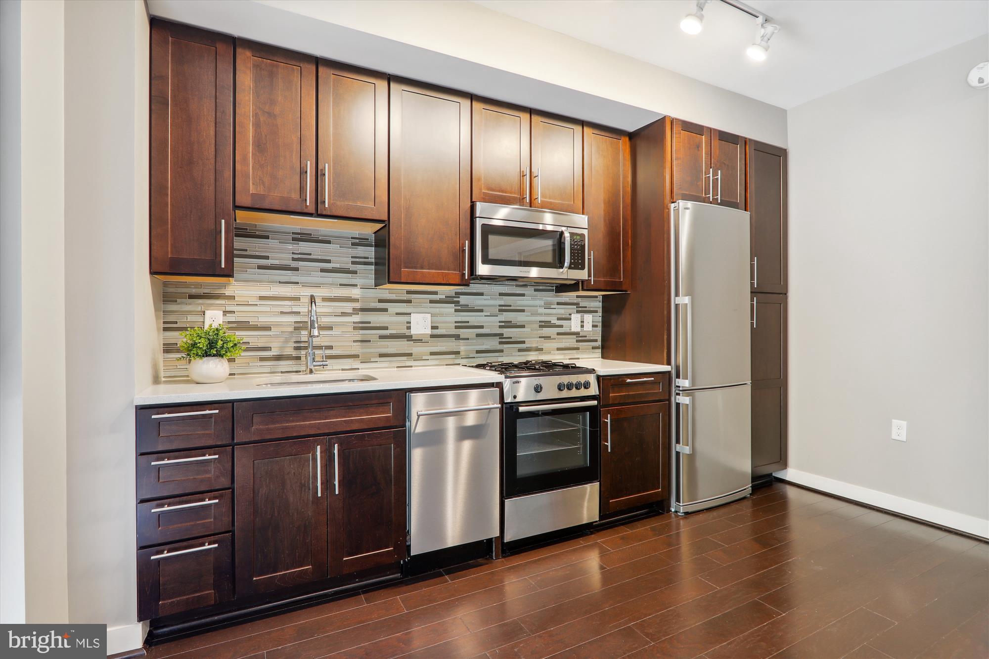 1320 Fenwick Lane, Unit 312 Silver Spring, MD 20910 - Photo 14 of 44 a kitchen with stainless steel appliances granite countertop a refrigerator and a sink