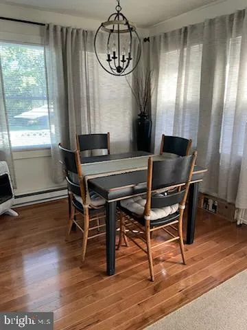 a dining room with furniture window and wooden floor