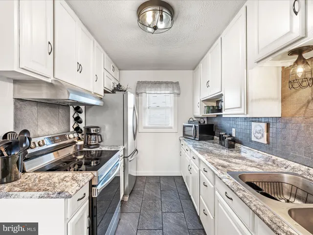 a kitchen with a stove sink and cabinets