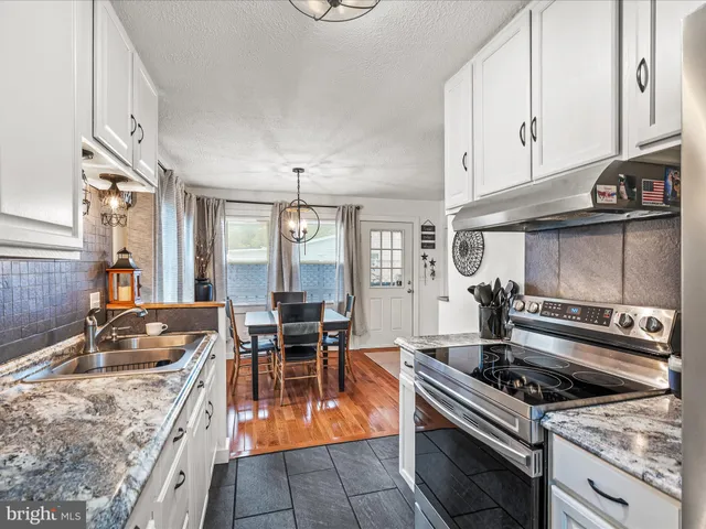 a kitchen with a stove a sink and a cabinets