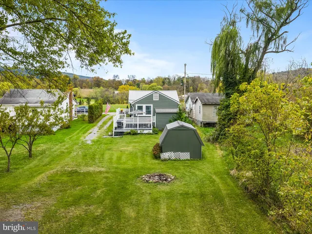 an aerial view of residential houses with outdoor space and trees