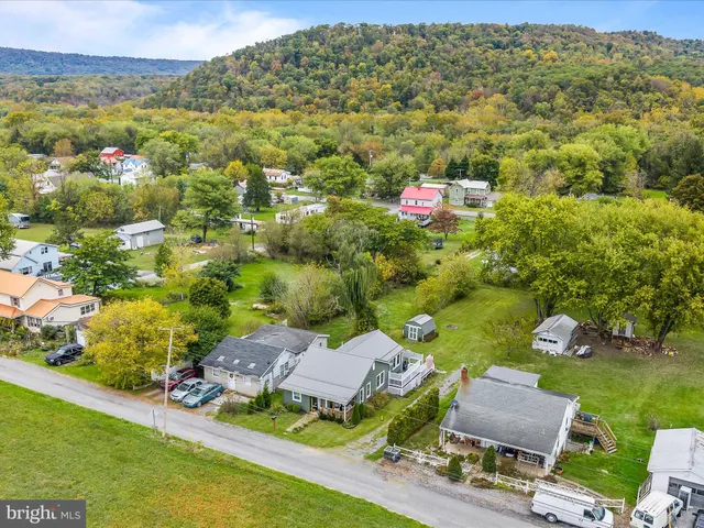 an aerial view of residential houses with outdoor space and lake view