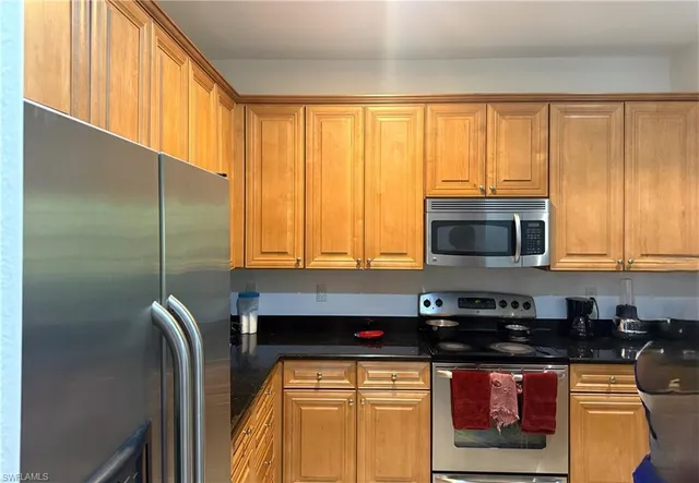 a kitchen with stainless steel appliances granite countertop a stove a sink and a microwave