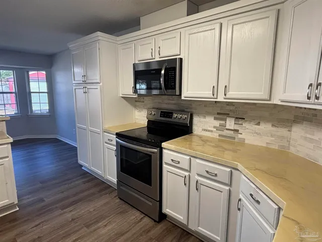 a kitchen with stainless steel appliances granite countertop a sink stove and microwave