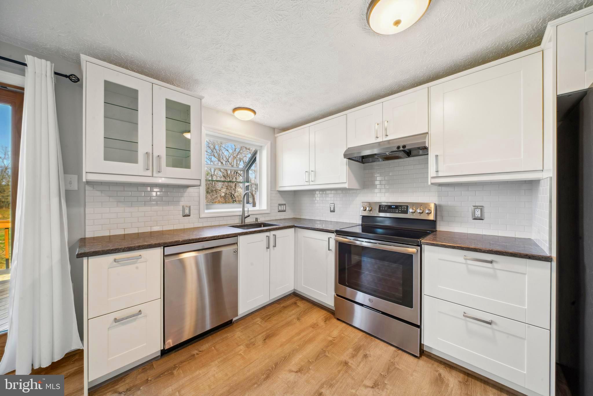 1335 Orchard Way Frederick, MD 21703 - Photo 13 of 42 a kitchen with granite countertop white cabinets and white appliances