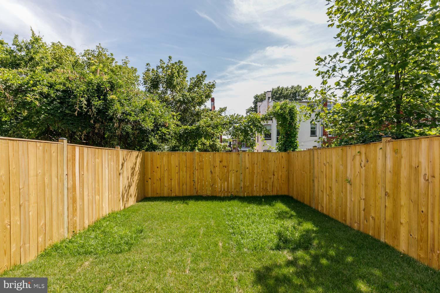 a view of yard with swimming pool and wooden fence