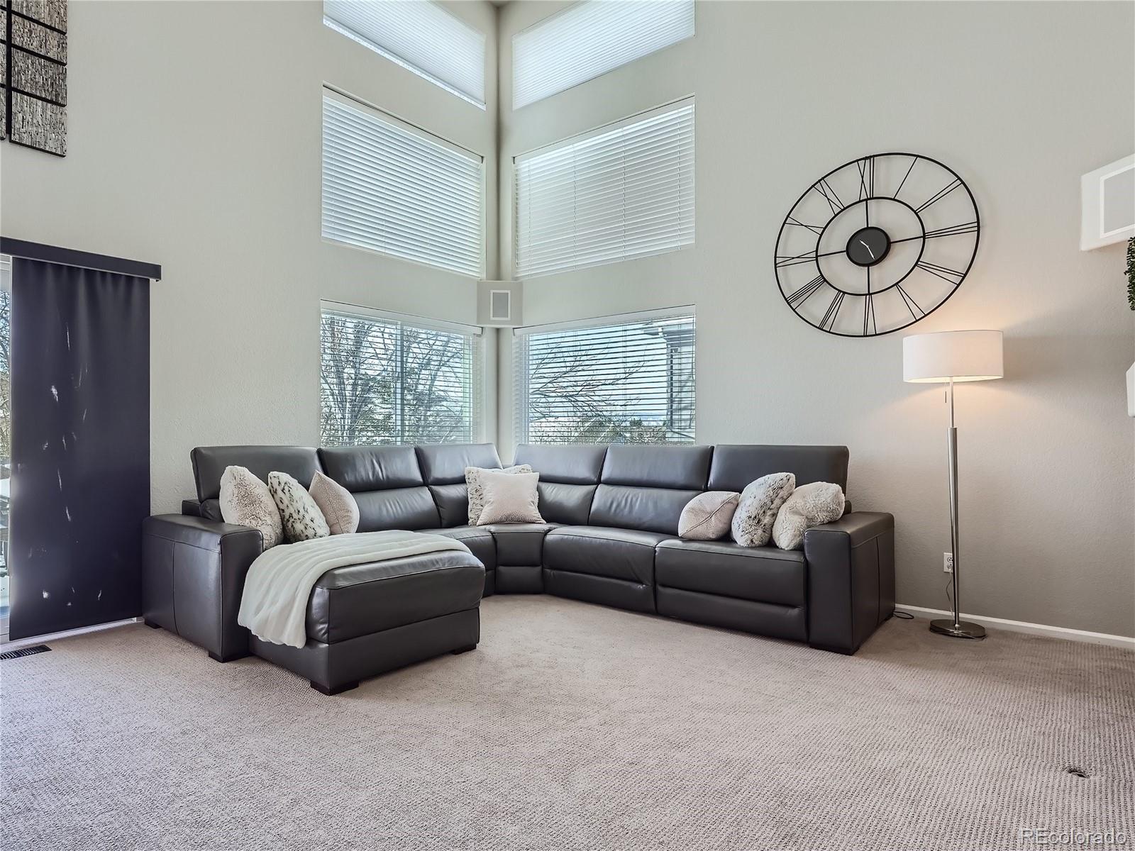 6596 Millstone Street Highlands Ranch, CO 80130 - Photo 13 of 33 a living room with furniture a large window and a chandelier