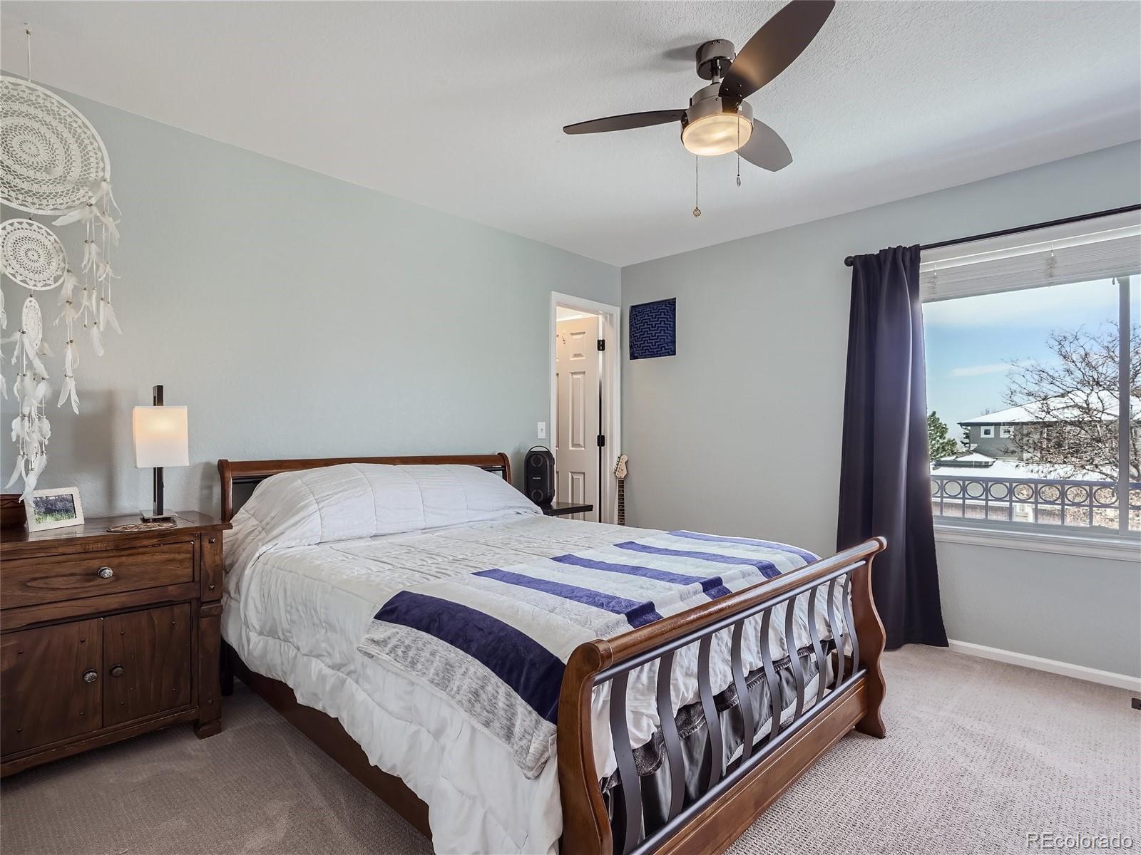 6596 Millstone Street Highlands Ranch, CO 80130 - Photo 20 of 33 a bedroom with a bed next to a window