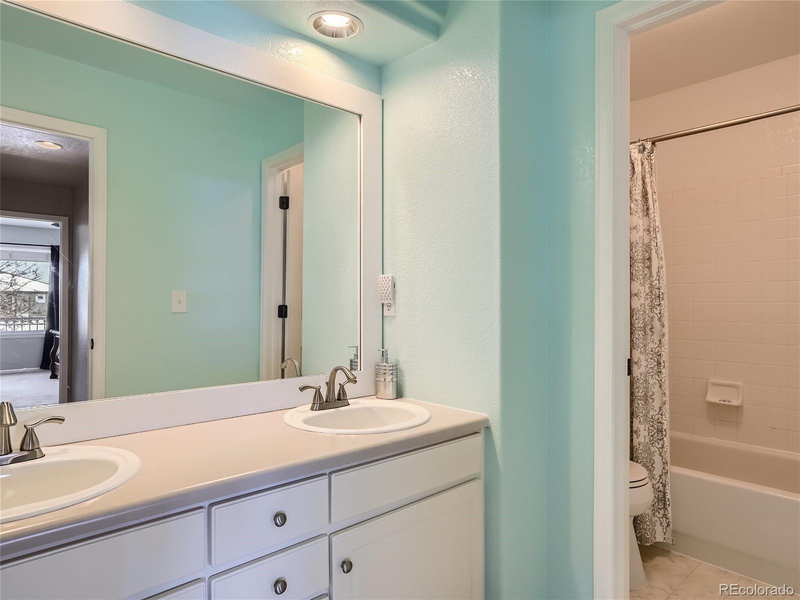 6596 Millstone Street Highlands Ranch, CO 80130 - Photo 22 of 33 a bathroom with a granite countertop sink and a mirror