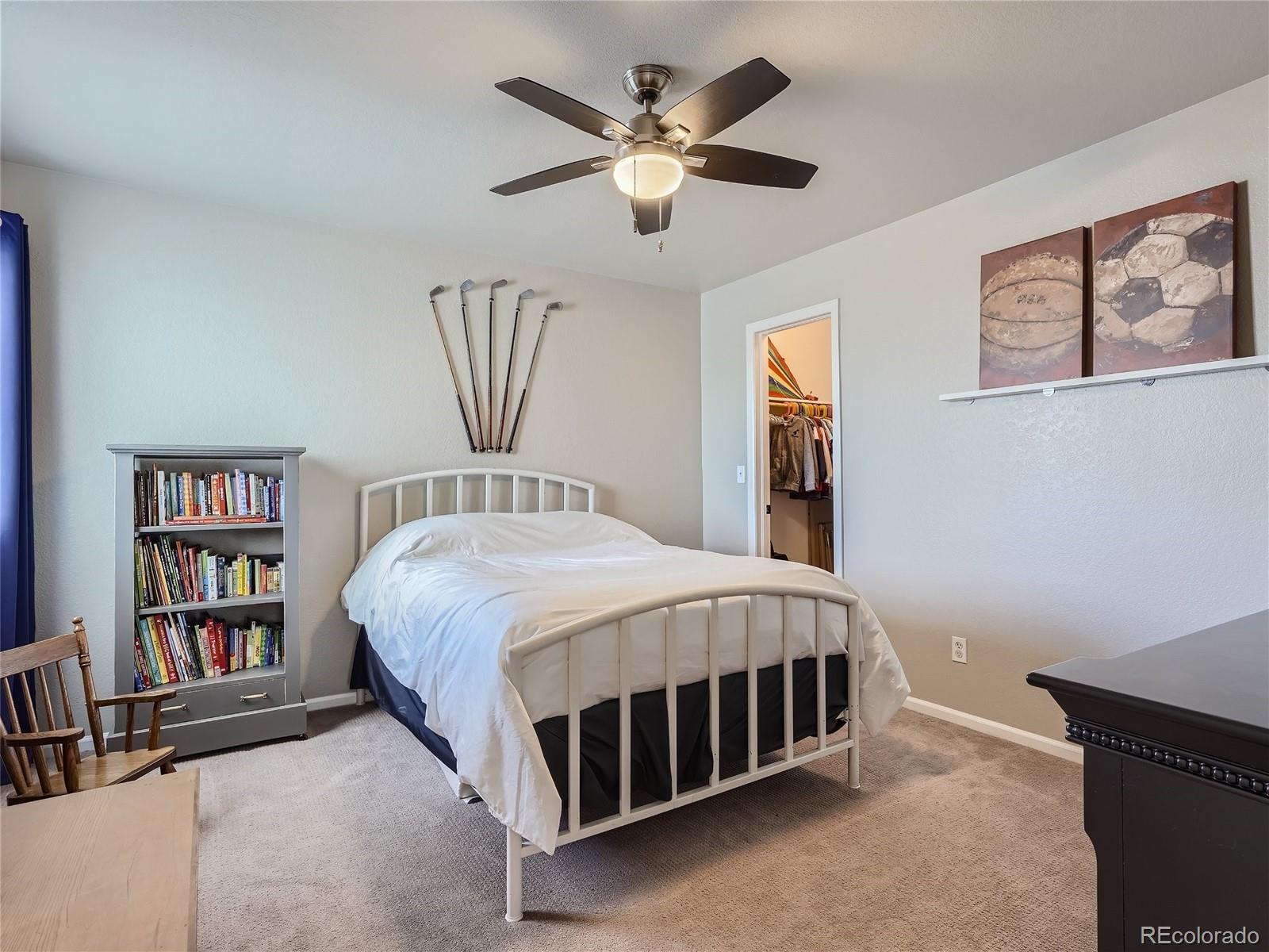 6596 Millstone Street Highlands Ranch, CO 80130 - Photo 23 of 33 a bed sitting in a bedroom next to a book shelf