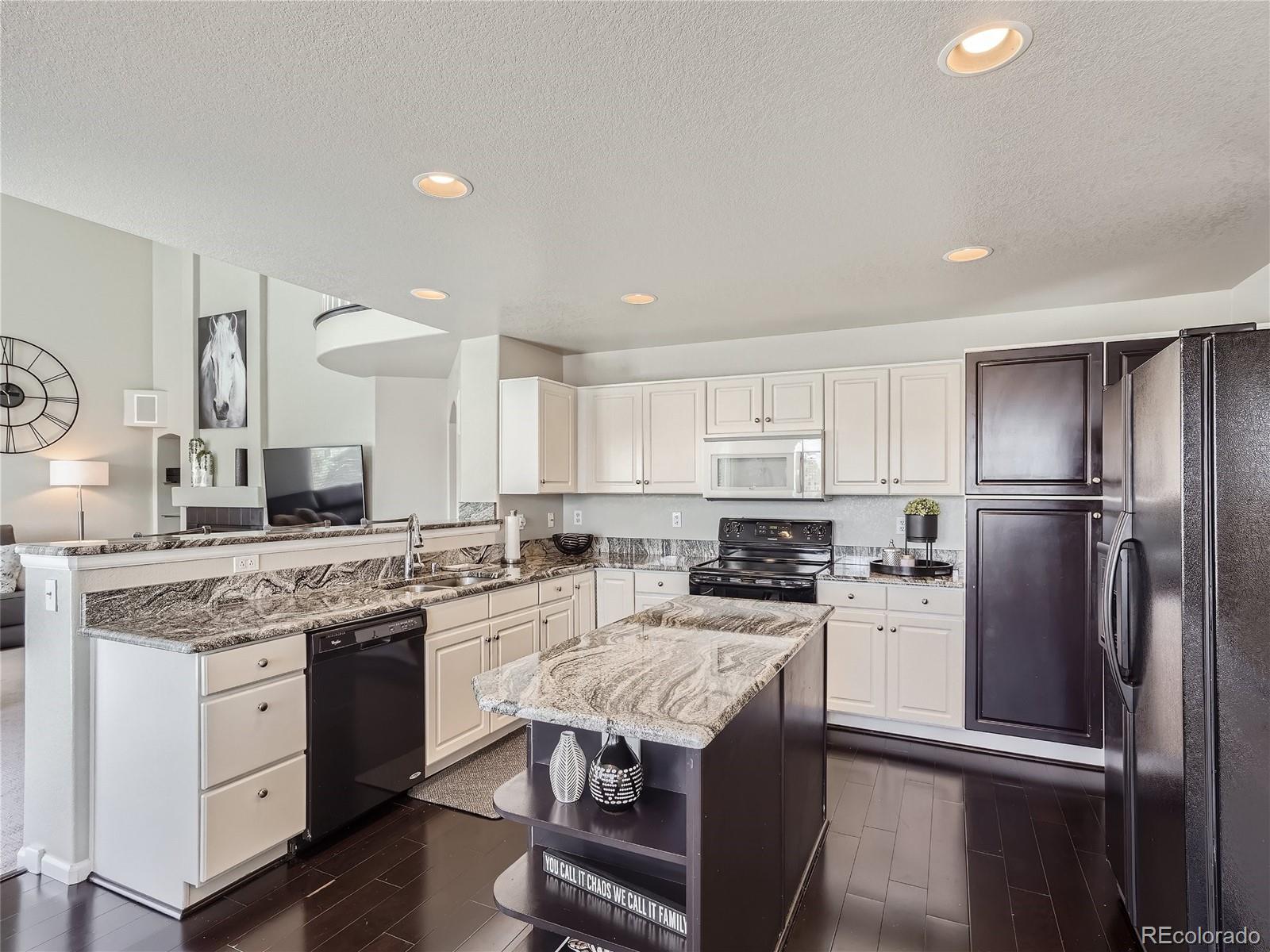 6596 Millstone Street Highlands Ranch, CO 80130 - Photo 10 of 33 a kitchen with stainless steel appliances granite countertop a stove a sink dishwasher a refrigerator and white cabinets with wooden floor
