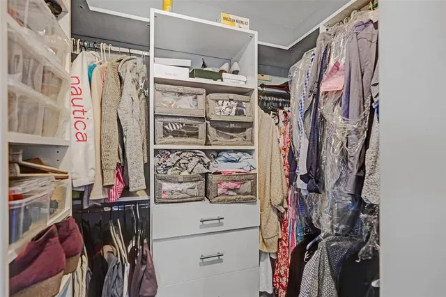 a view of walk in closet with clothes