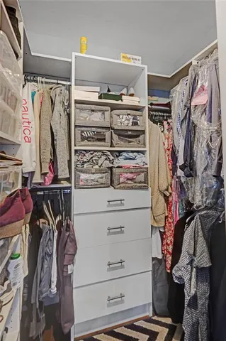 a view of walk in closet with clothes and shoes