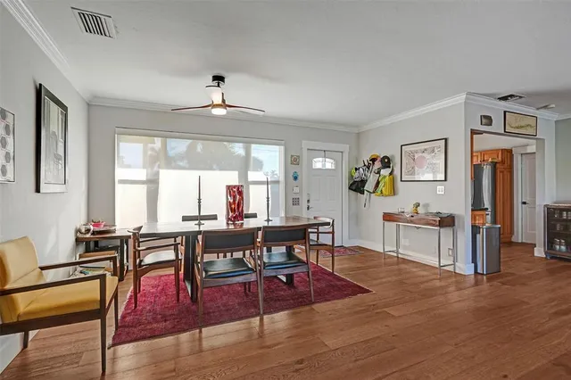 a living room with furniture dining table and wooden floor