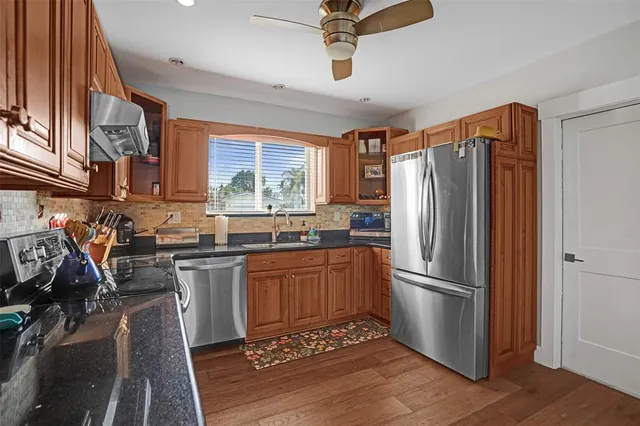 a kitchen with stainless steel appliances granite countertop a refrigerator and a sink