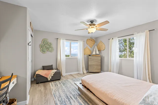 a bedroom with a bed ceiling fan and a window