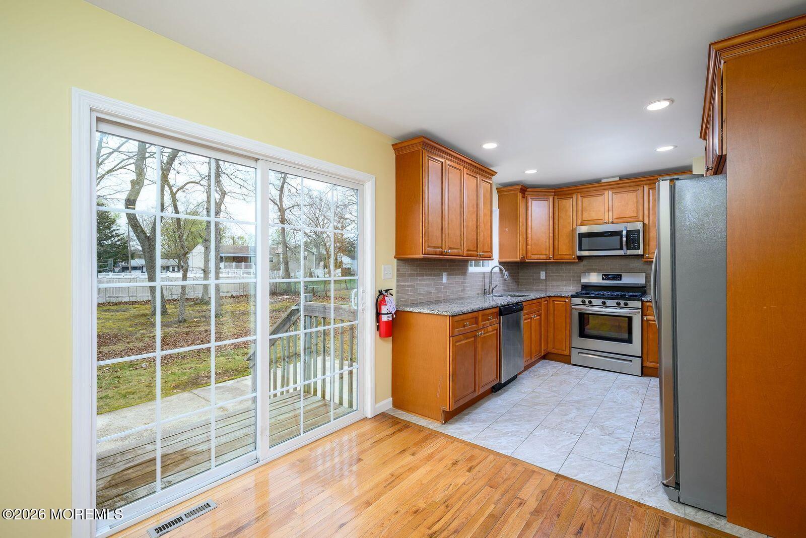 19 Princeton Drive Howell, NJ 07731 - Photo 7 of 36 a kitchen with stainless steel appliances granite countertop a stove a sink and a refrigerator