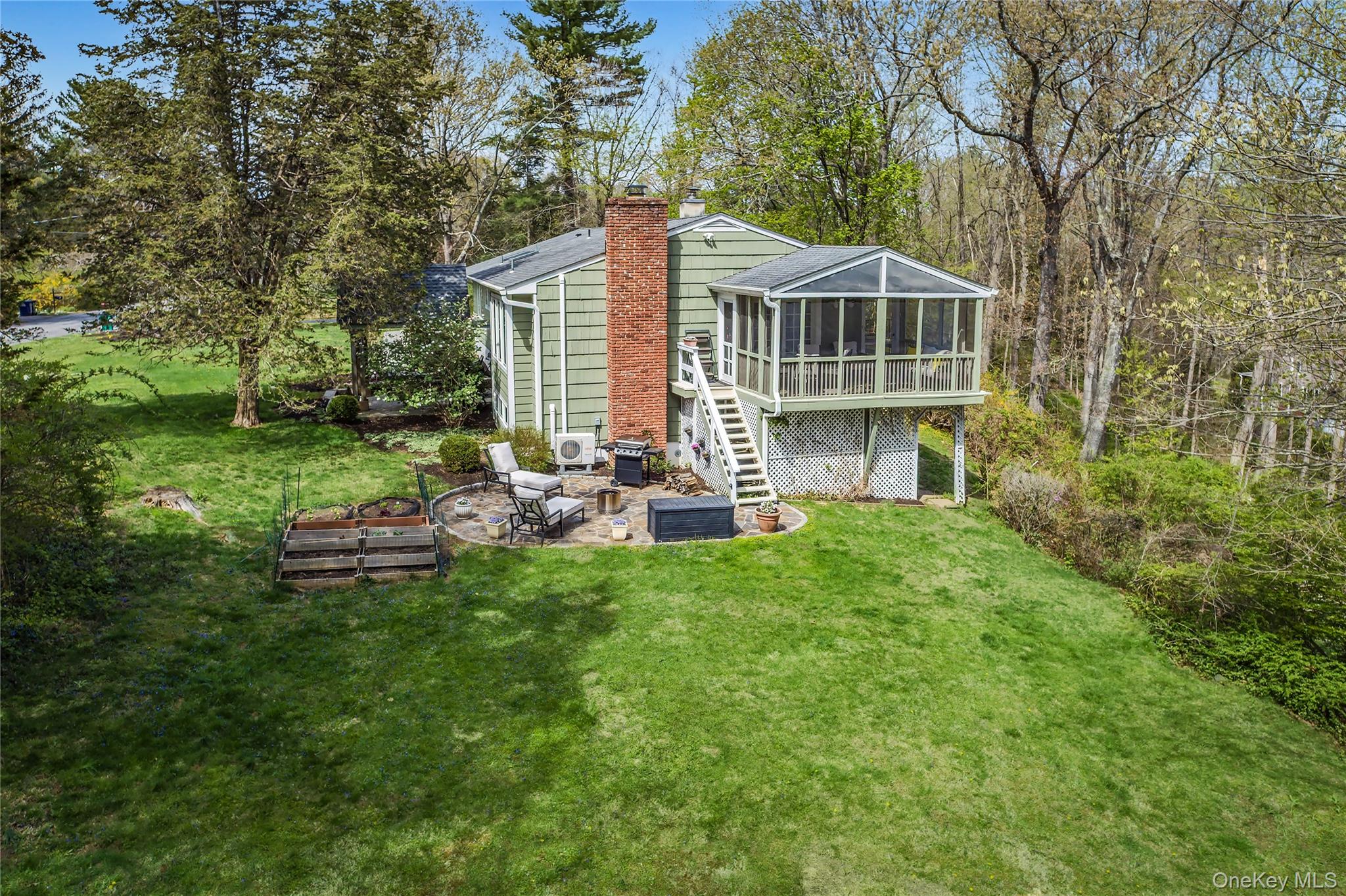 41 Cross Pond Road Pound Ridge, NY 10576 - Photo 39 of 41 a view of a house with backyard sitting area and garden